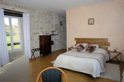 una camera da letto con un letto grande e una finestra di Le domaine de l'Escadasse a Faycelles