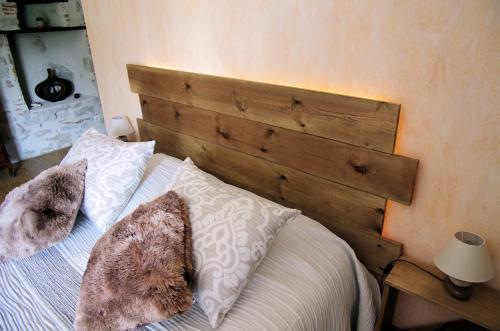 una camera da letto con un letto con testiera in legno di Le domaine de l'Escadasse a Faycelles