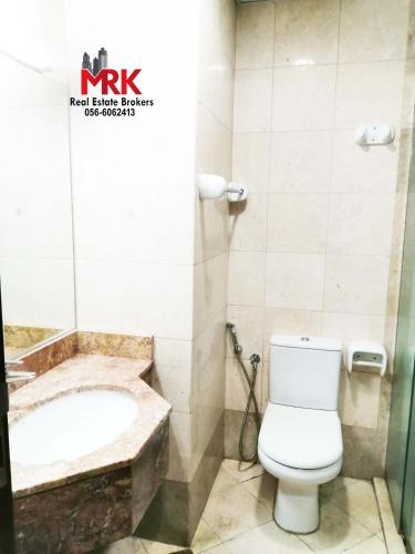 a bathroom with a toilet and a bath tub at Studio Apartment in Dubai
