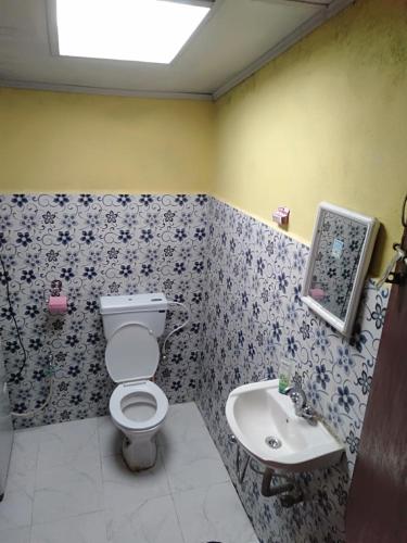a bathroom with a toilet and a sink at Vamoose Phoolbari in Khaprail