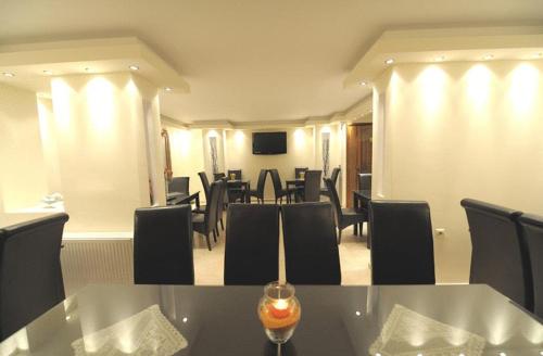 a dining room with tables and chairs and a television at Panorama Spa Hotel in Ouranoupoli