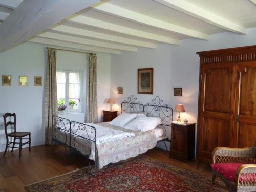 a bedroom with a bed and a table and chairs at Chambres d'hôtes Les Pesques in Palaminy