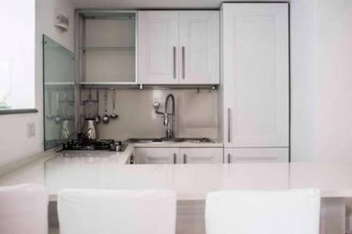 a kitchen with white cabinets and a sink at Casa Vacanza Al Centro di Capri in Capri