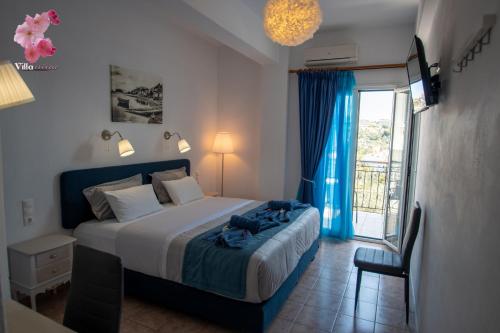 a bedroom with a bed and a sliding glass door at Villa Nina in Skiathos Town