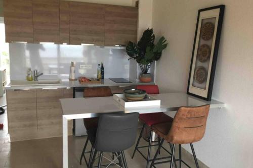 une cuisine avec un comptoir et des tabourets dans une pièce dans l'établissement T3 vue exceptionnelle avec accès privé à la plage, wifi, clim - dansnotreappart-com -, à Valras-Plage