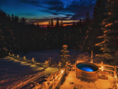 a hot tub in the snow at night at Leśna Bacówka in Nowy Targ