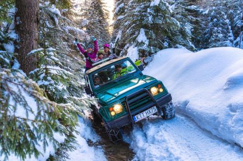 a group of people riding in a jeep in the snow at Leśna Bacówka in Nowy Targ