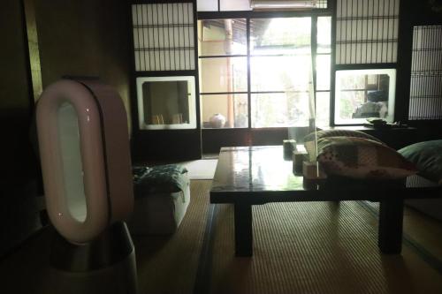 a bathroom with a urinal and a table and a window at Gallery Nozawa Inn in Kyoto