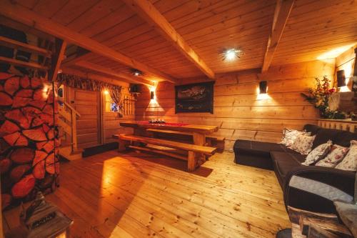 a living room with a table in a wooden cabin at Leśna Bacówka in Nowy Targ