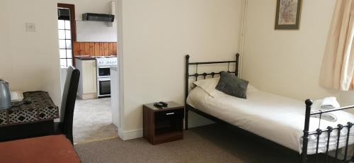a bedroom with a bed and a table in a room at Arman Lodge House in Peterborough