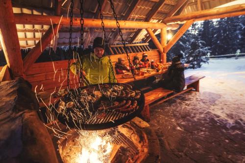 a man sitting at a table in a cabin with food at Leśna Bacówka in Nowy Targ