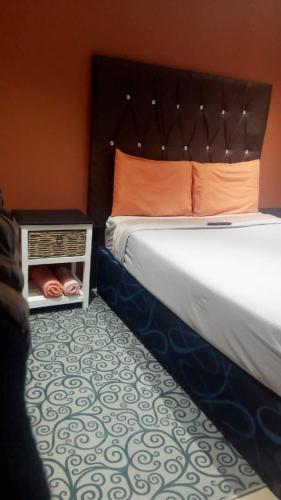 a bedroom with a large bed with an orange wall at FK Guest Inn in Alberton