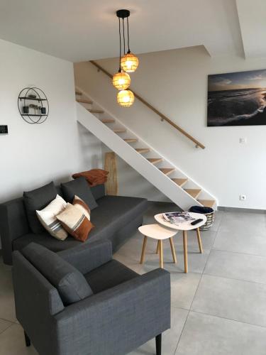 a living room with a couch and a staircase at Whaaw Oostende in Ostend