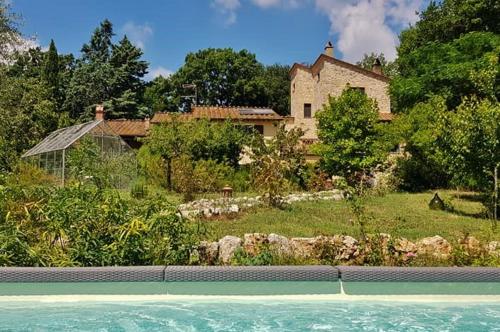 una casa e una piscina di fronte a una casa di B&B and Wellness Il Pomario di Montepiglio Resort Naturista ad Amelia