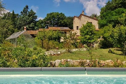a house and a swimming pool in front of a house at B&B and Wellness Il Pomario di Montepiglio Resort Naturista in Amelia