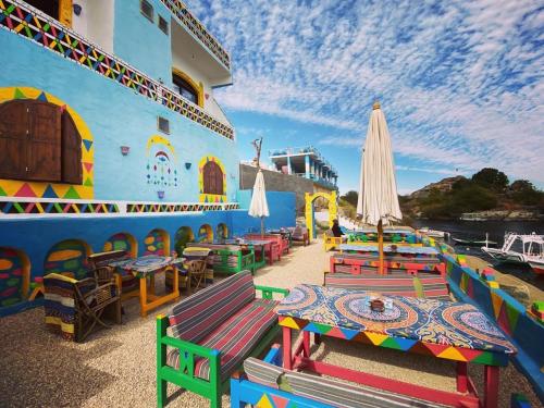 a cruise ship with colorful tables and an umbrella at Kendaka Nubian House in Aswan