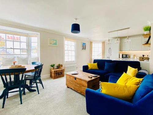 a living room with a blue couch and a table at Nickleby Nook By the Sea - Meters to the Beach! in Broadstairs