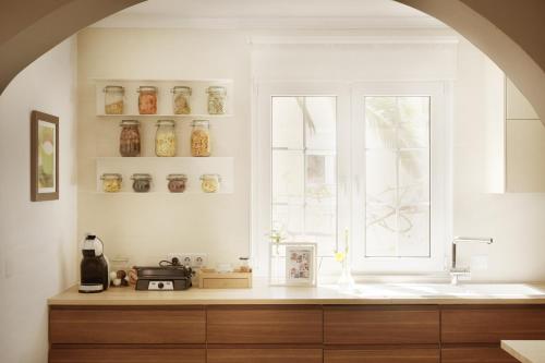 a kitchen with a sink and a window with jars at Villa Eliza in Denia