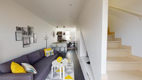 a living room with a purple couch and a table at PARIS HOUSE in Villejust