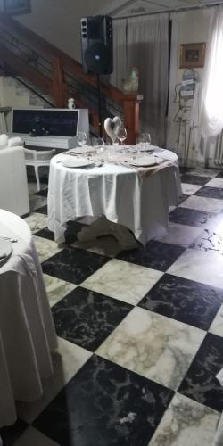 a black and white checkered floor with a table in a room at La Gallina Nel Castello in Albenga