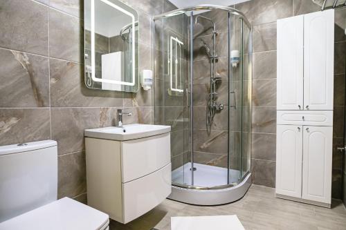 a bathroom with a shower and a toilet and a sink at Yasuo Beach Apartment in Mamaia Sat/Năvodari