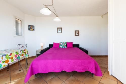 - un grand lit rose dans une chambre blanche dans l'établissement Observatoire, à Nice