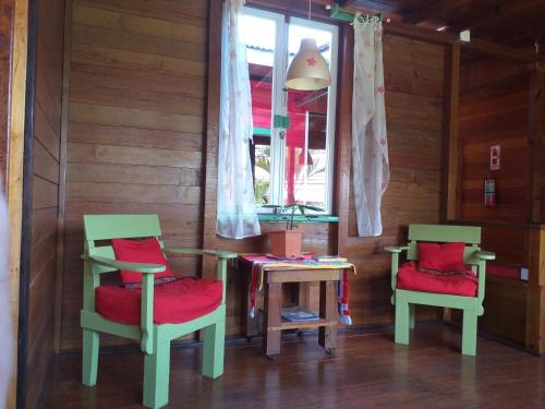 two chairs and a table in a room at Hostal Hansi in Bocas Town