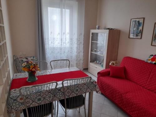 een woonkamer met een rode tafel en een bank bij Appartamento Centrale con garage in Asti