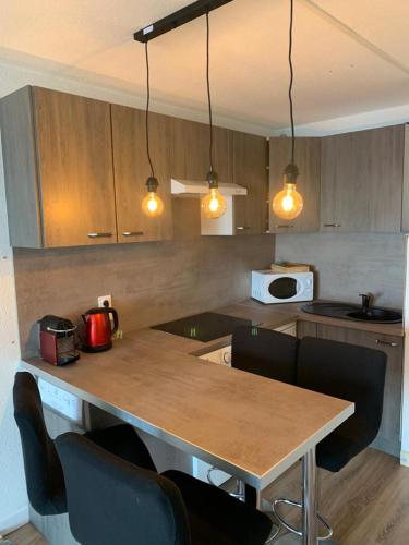 une cuisine avec une table et des chaises et un micro-ondes dans l'établissement Studio Face à la mer..., à Sète