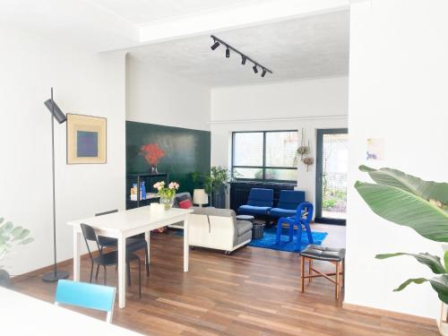 a living room with a white table and blue chairs at B&B Expo House in Antwerp