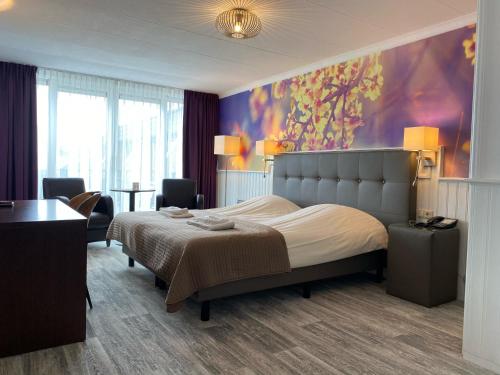 una camera da letto con un letto e un dipinto sul muro di Hotel Cafe Restaurant Duinzicht a Schiermonnikoog