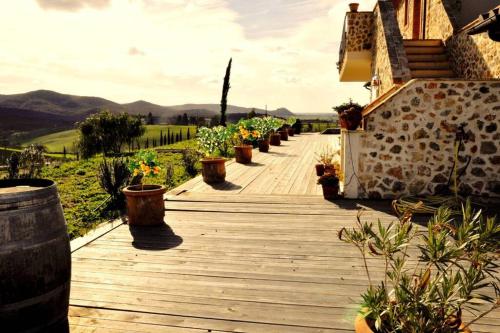 a wooden walkway with potted plants on a house at montecristo country house in Marsiliana