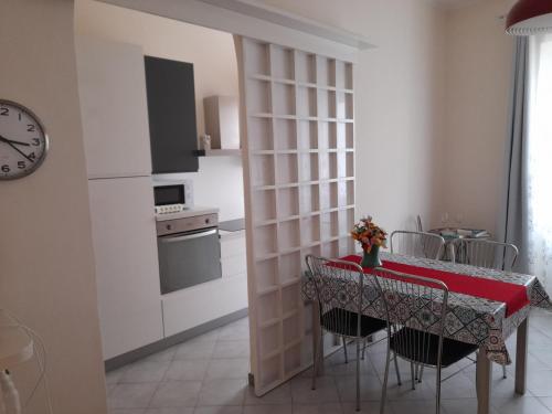 eine Küche mit einem Tisch mit Stühlen und einer Uhr in der Unterkunft Appartamento Centrale con garage in Asti