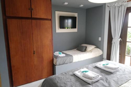 a bedroom with two beds and a cabinet and a tv at MODERNO MONOAMBIENTE- LA CALLEJA APART in Olavarría
