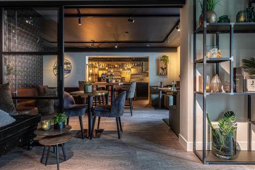 een restaurant met tafels en stoelen en een bar bij Hotel Kogerstaete Texel in De Koog