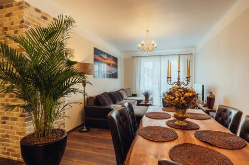a dining room with a table and a couch at Rezidence Liepas in Liepāja
