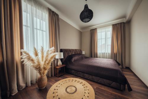 um quarto com uma cama e uma grande janela em Rezidence Liepas em Liepāja