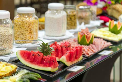 a buffet of food with water melons and other foods at Rede Andrade Amazônia in Manaus