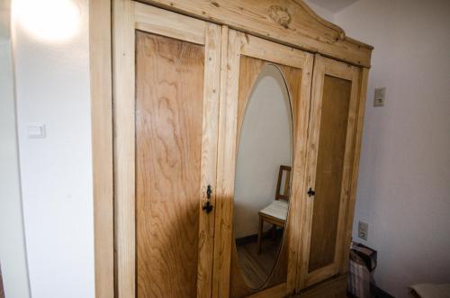 a wooden cabinet with a mirror in a room at Ferienwohnung Scandic Hygge Bevern im Weserbergland in Bevern