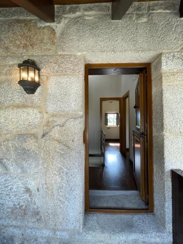 a hallway with a mirror on a stone wall at Casa Casoa in Piornedo