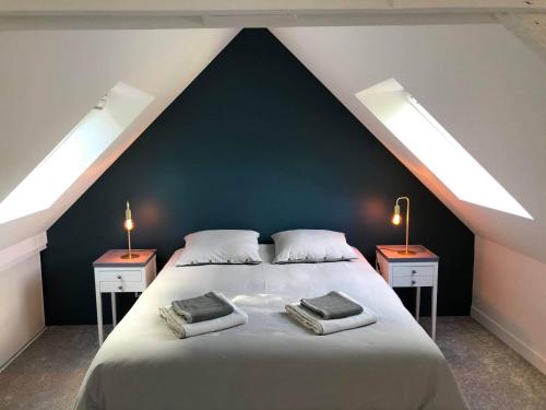 a bedroom with a large bed with two night stands at Maison 2 Ch - 7 Pers - au coeur du Château de Bothané in Guidel