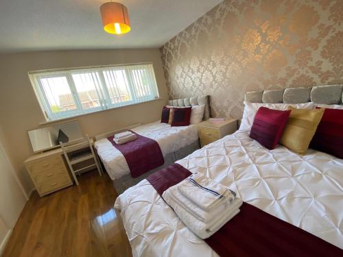1 Schlafzimmer mit 2 Einzelbetten und einem Fenster in der Unterkunft GARDNER HOLIDAYS HOUSE in Manchester