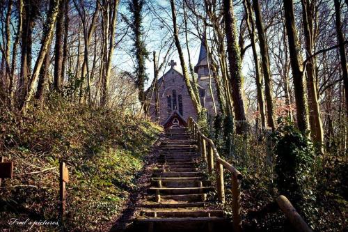 un conjunto de escaleras que conducen a una iglesia antigua en Gite Le Minile, en Béthencourt-sur-Mer