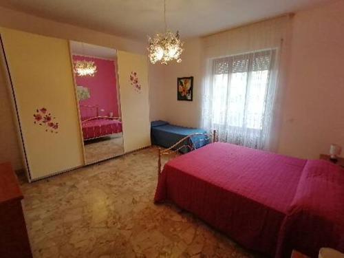 a bedroom with a pink bed and a large mirror at Appartamento CUPRA in Cupra Marittima