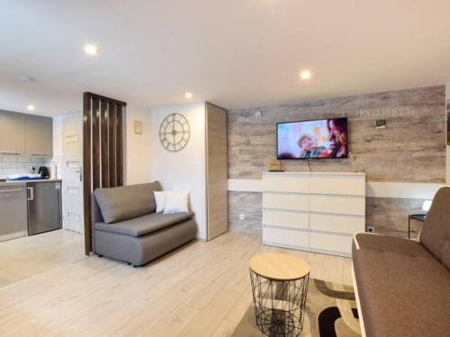 a living room with a couch and a tv on a wall at Apartamenty Górski Strumyk in Karpacz
