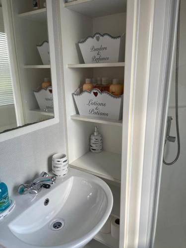 a bathroom with a sink and a mirror at Holiday Home Breaks At Tattershall Lakes in Lincoln