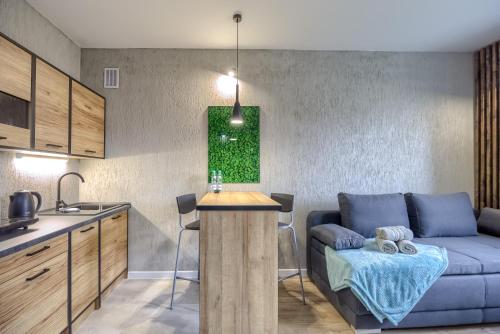 a kitchen and a living room with a couch and a table at Niron Apartamenty Spacerowa in Piła