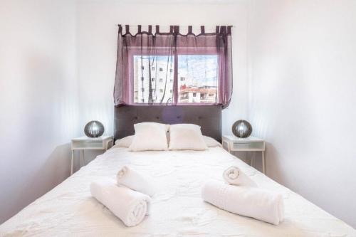 una camera da letto con un grande letto bianco con due cuscini di Bubu Beach 3 a Los Cristianos