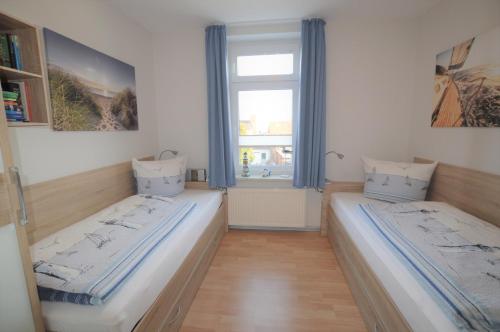two beds in a room with a window at Urlaubsdomizil InselLust-Rügen in Sassnitz