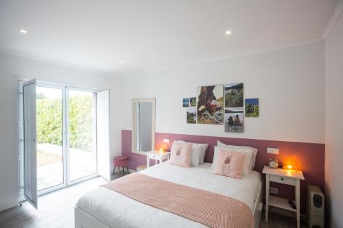 a bedroom with a large bed with pink walls at Bicycle Villas - AL in Ponta Delgada